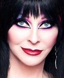 he image is a closeup portrait of elvira, mistress of the dark, a horror hostess who is known for her gothic attire and spooky makeup.  she is staring at the camera with a mischievous smile and has her hair pulled back in a sleek, dark style. she is wearing heavy eye makeup with black eyeliner, bright pink eyeshadow, and long, dark lashes. her lips are painted a bright red. she is also wearing a large, silver hoop earring.