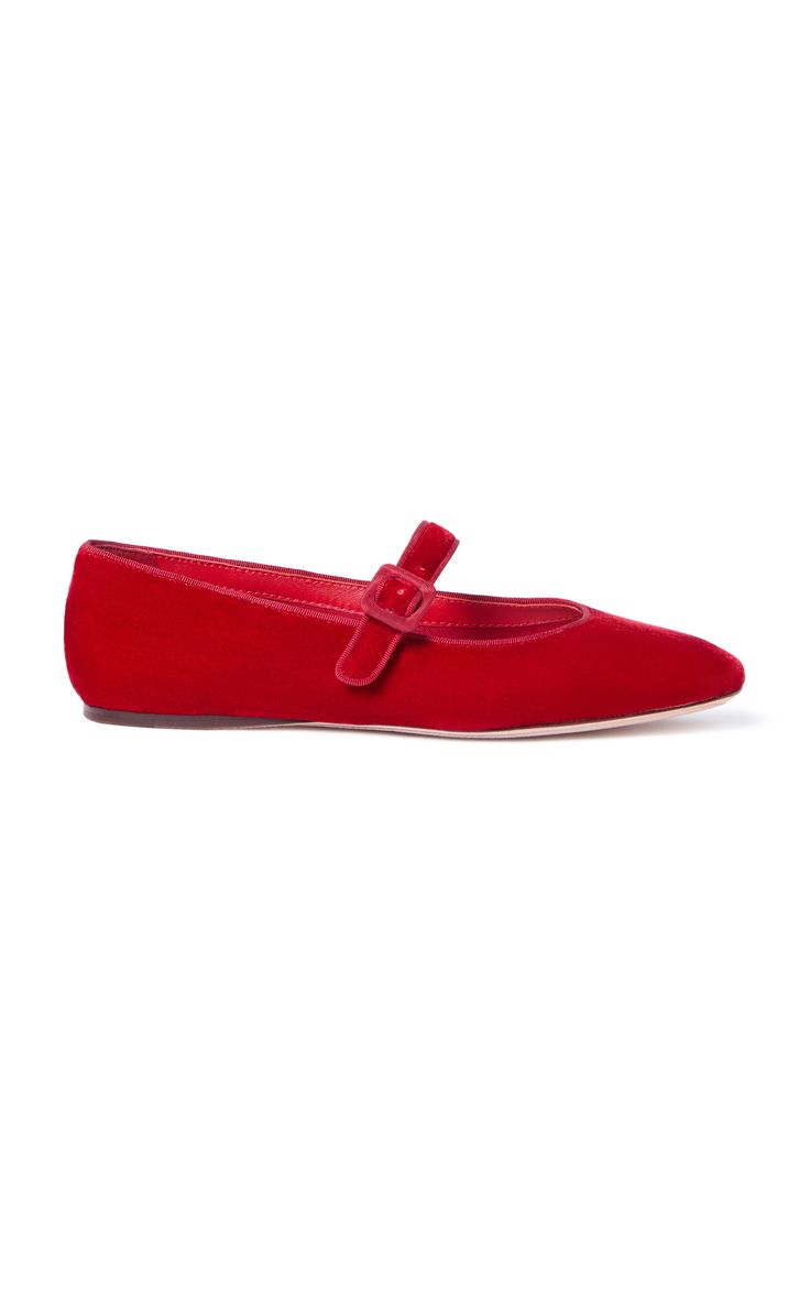 a single red velvet women's mary jane flat is shown against a white background.  the shoe has a pointed toe and a single buckle strap across the instep. the shoe appears to be made of a soft, plush velvet fabric.