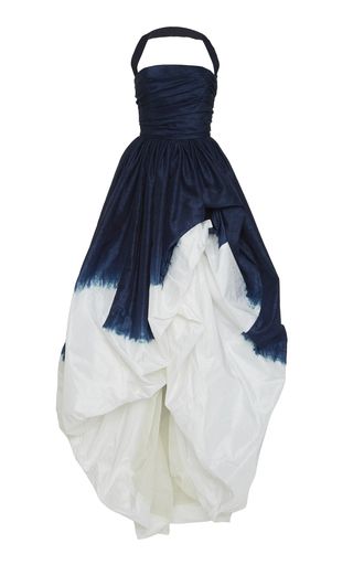 a strapless halterneck dress with an indigo bodice and a white puffy skirt is pictured against a white background. the indigo color fades into the white of the skirt in a tiedye pattern. the dress appears to be made of a light, possibly silky fabric. the halter neck is a darker indigo, contrasting with the lighter tone of the bodice. the skirt has a voluminous and somewhat irregular shape, with folds and gathers creating the puffy effect.