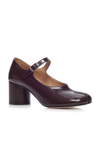 a pair of maroon leather women's heels with a square toe and a block heel. they have a buckle strap over the instep and are made of polished leather.