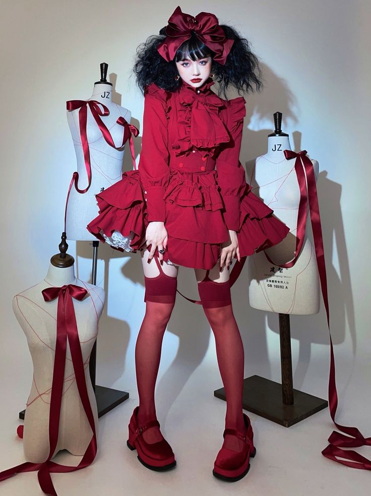 a young woman in a red dress with frills and a bow, wearing red stockings and shoes, poses in front of two mannequins. the mannequins are also dressed in red and have bows. the woman is surrounded by red ribbons. the overall style is gothic lolita, and the image is very dramatic and elegant. the girl looks very cute and adorable in her outfit. the image is very wellcomposed and the lighting is excellent.