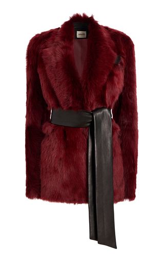 a red fur coat with a black leather belt is shown on a white background.