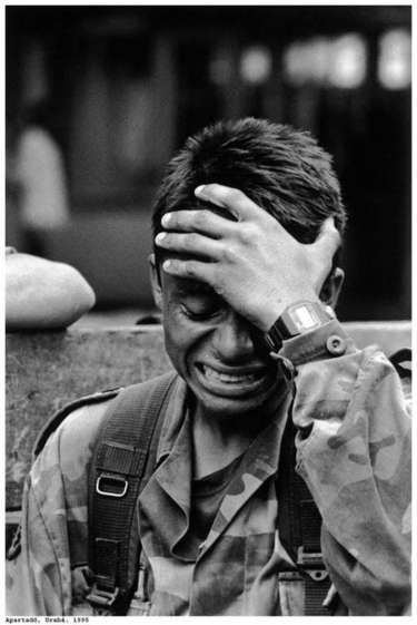 a closeup black and white image of a soldier crying. he is wearing a military uniform and a backpack. he looks sad and dejected, as if he is grieving the loss of a comrade. the image captures the raw emotions of war and the toll it can take on those who fight in it.  the image has a strong sense of realism and immediacy. the soldier's tears are visible, and his face is contorted in anguish. he appears to be overwhelmed by his emotions. the image is a reminder of the human cost of war.