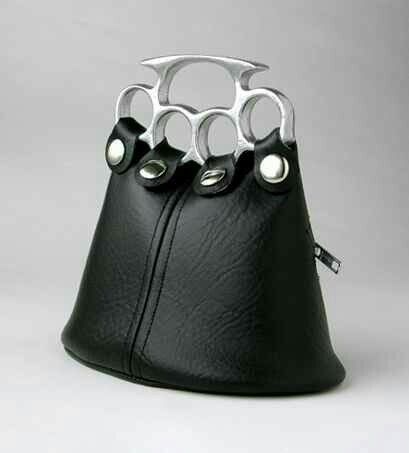 a black leather handbag with a handle made of a knuckle duster.