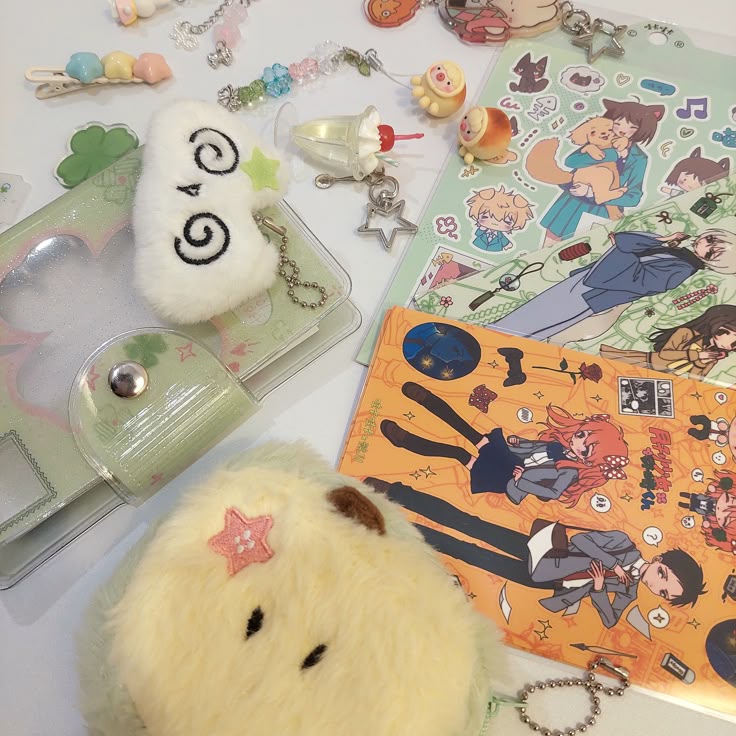 this image shows a collection of cute and kawaiithemed items. there are anime character stickers, plushies, keychains with sweets and star designs, colorful hair clips, a green notebook with a heartshaped window, and other small stationery items. the arrangement gives a whimsical and playful feel.