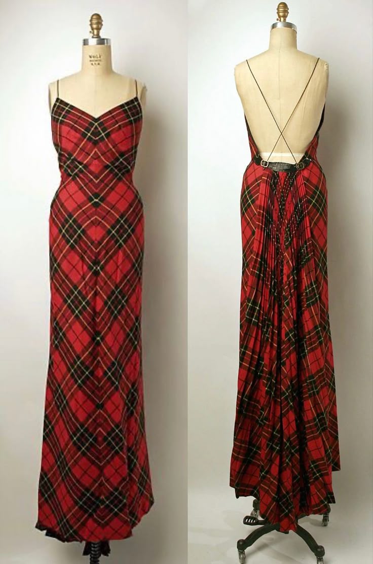 the image shows a red plaid dress with spaghetti straps and a vneck. it is full length and has a low back with pleats. the dress has a belt. it is displayed on a mannequin.