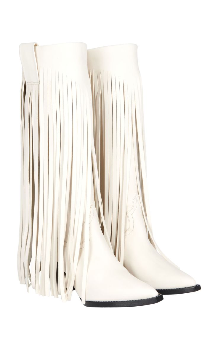 a pair of white leather cowboy boots with long fringe are shown against a white background. the boots are pointedtoe and have a slight heel.  the fringe extends from the top of the boot shaft almost to the sole.  the boots appear to be made of soft leather.