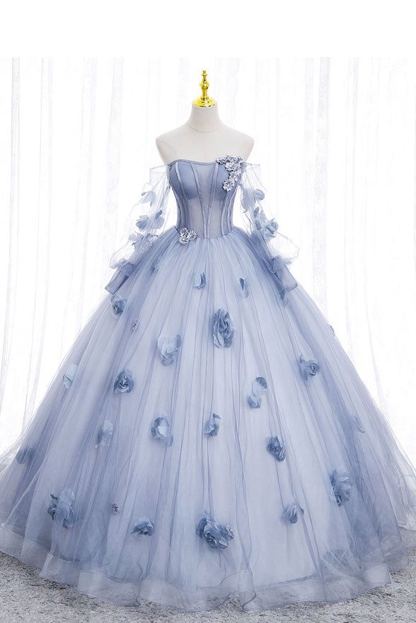 a beautiful blue tulle ball gown with floral appliques and lace details. the gown is strapless with a fitted bodice and a full, flowing skirt. it is perfect for a prom, wedding, or any special occasion.
