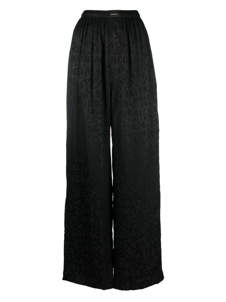 a pair of black, wideleg pants with an allover balenciaga logo print. they appear to be made of a silky fabric and have a highwaisted fit.