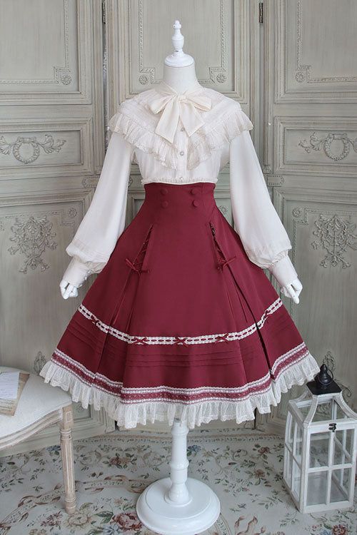 a fulllength image of a classic lolita fashion outfit on a mannequin.  the outfit consists of a white blouse with ruffled collar and sleeves, tied with a ribbon at the neck, and a burgundy skirt with lace trim and details. the skirt is full and falls to the floor, suggesting the use of a petticoat underneath. the mannequin is positioned against a white paneled wall with decorative molding.  the scene is brightly lit, likely with artificial lighting.