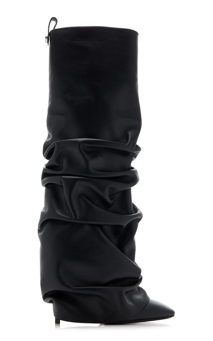 a studio shot against a white background shows a pair of women's black leather slouchy kneehigh boots. the boots are made of soft, supple leather that is gathered and draped in a relaxed, casual style.  the boots have a pointed toe and a low heel. they appear to be made of highquality leather. the overall style is elegant, yet casual and fashionable.