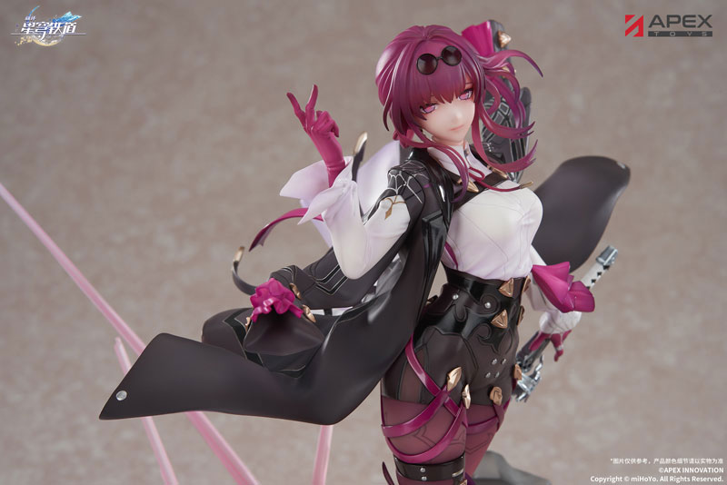 this is a promotional image of a figure of the character kafka from the game honkai: star rail, created by apex toys. kafka is a woman with reddishpurple hair, pale skin, and dark glasses on her forehead. she is wearing a complex outfit with black, white, and pink accents, including a white blouse, a black jacket, and detailed black pants with pink accents. she is posed making a "peace" sign with one hand and has a sword at her hip. the figure is displayed against a neutral background with subtle lighting, and there are logos for honkai: star rail and apex toys in the upper corners.