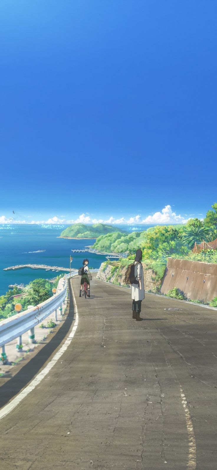 the image is a still from an anime film or tv show, depicting a scenic coastal road winding up a hill toward a picturesque background. two young individuals are seen on the road; a girl riding a bicycle and a boy slightly ahead standing still with a backpack. the background includes a clear blue sky, a calm ocean with a harbor visible in the distance, lush green hills with some vegetation and small buildings on the shore. the road's surface is asphalt, with a white line marking the edge.  the overall mood is peaceful and serene. the animation style is distinct and characteristic of contemporary anime.