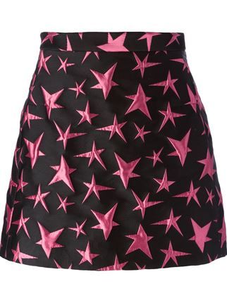 a black miniskirt with a pink star pattern is showcased. the skirt has a subtle aline shape and appears to be made from a textured fabric, possibly jacquard or brocade. the pink stars vary in size and orientation, creating a dynamic and playful design against the dark background. the waistband is visible at the top of the skirt. the overall impression is a fashionable and eyecatching garment.