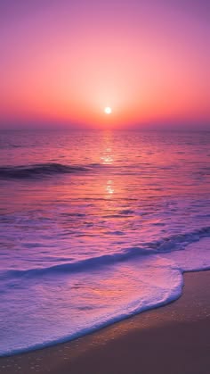 a breathtaking sunset over the ocean. the sky is a vibrant pink and purple, and the sun is setting over the horizon. the waves are gently crashing on the sandy beach, creating a tranquil and serene atmosphere.  the scene is perfect for a relaxing evening or a romantic getaway.