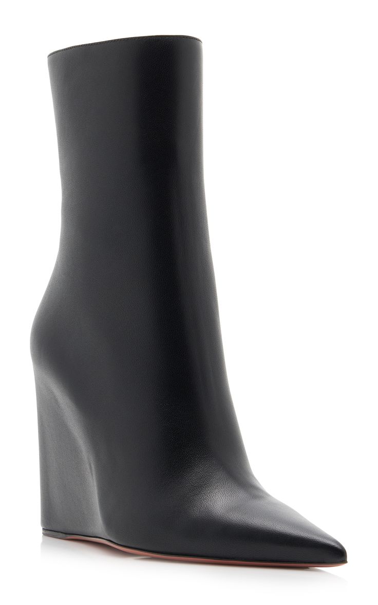 the image shows a pair of women's black leather wedge ankle boots. the boots have a pointed toe and a hidden wedge heel. they are made of smooth leather and have a sleek, sophisticated look. the boots are shown against a white background.