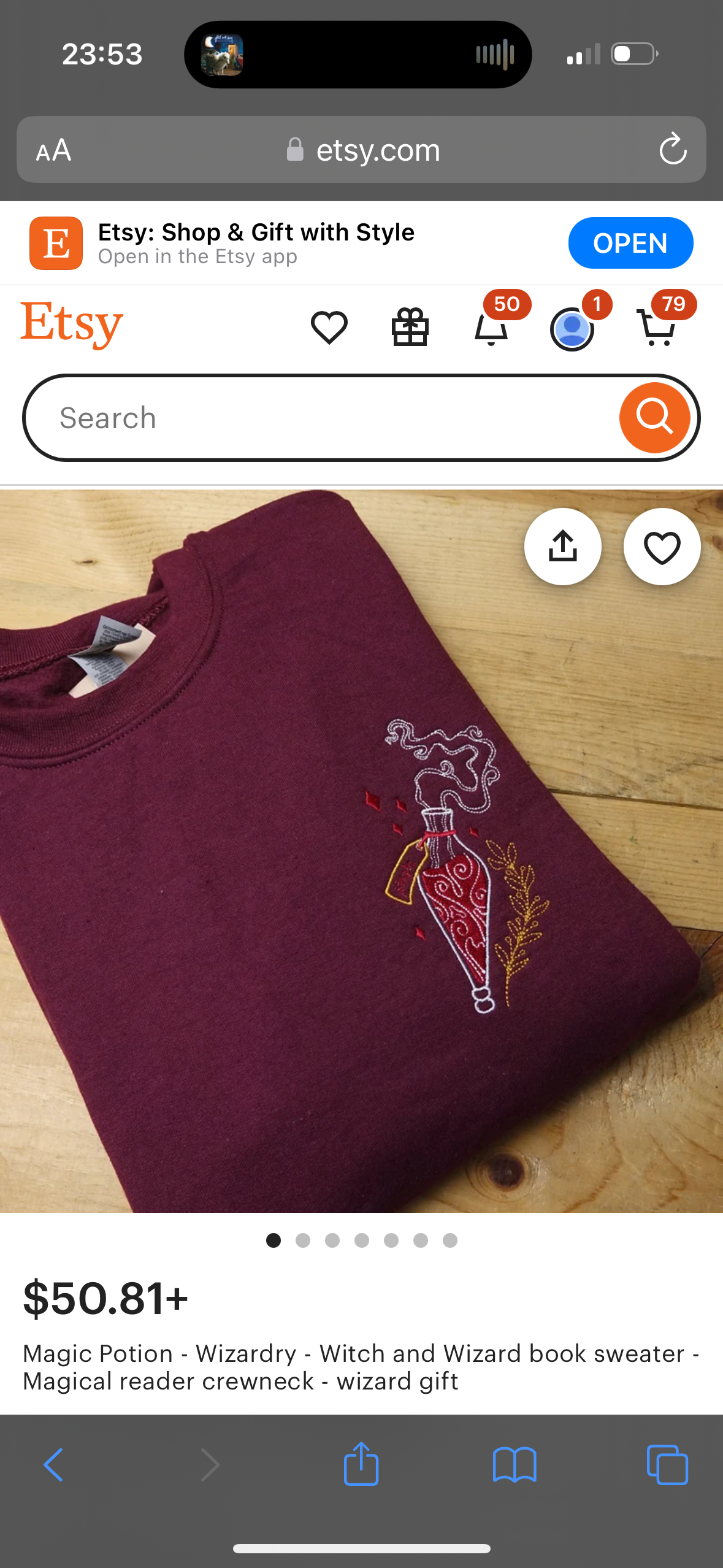 a picture of a maroon crewneck sweater with an embroidered image of a potion bottle and magic smoke on it. it is laid out on a wooden surface with a wooden background. the sweater has a white embroidered design on it.  the etsy logo is at the top of the picture with the title and description of the sweater below the picture.