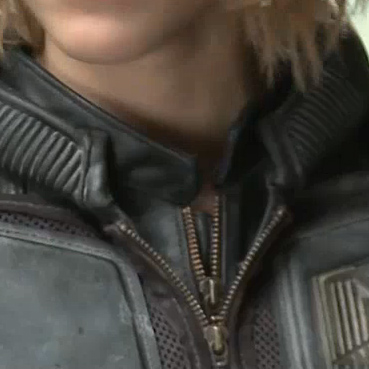 close up of a leather jacket zipper with a collar. the zipper is metal and the collar is leather with a textured pattern. the jacket is black and appears to be a motorcycle jacket.