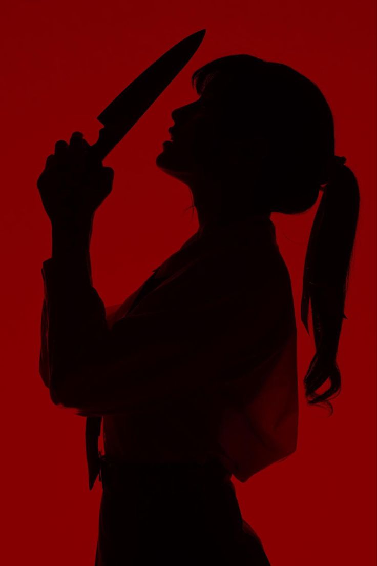 a silhouette of a woman holding a knife in a dark red background. she looks mysterious and dangerous, creating a thriller and crime mood. the woman's pose and the knife create a dramatic and intense atmosphere.