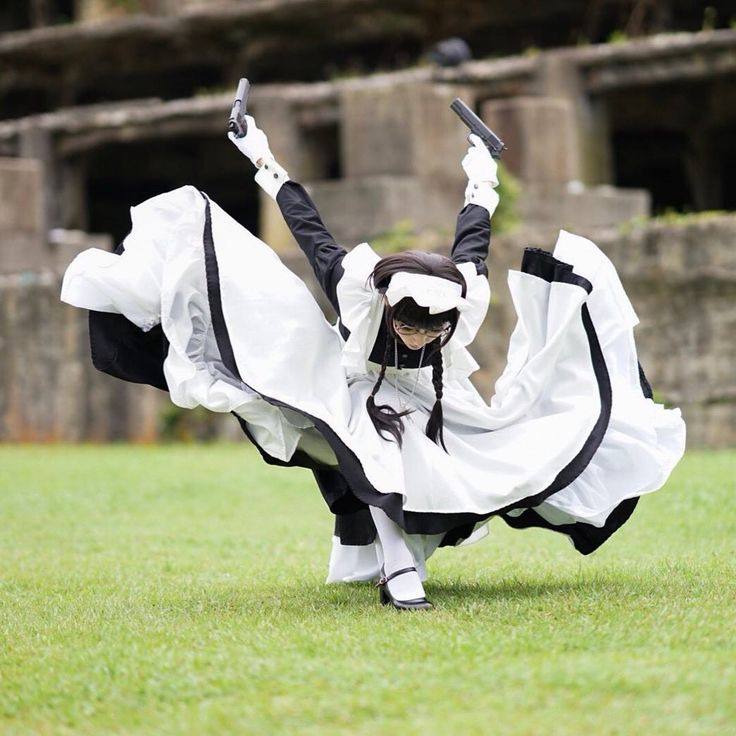 a woman in a black and white maid outfit with a gun in each hand, posing with her dress flared out. she is standing in a grassy field outdoors with a green grassy background.