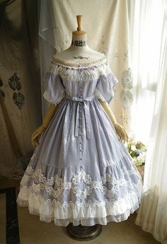 a fulllength view of a light purple lolita dress displayed on a mannequin. the dress features offshoulder sleeves, delicate lace trim, and intricate embroidery.  the soft lighting and neutral background emphasize the romantic and whimsical design of the garment.