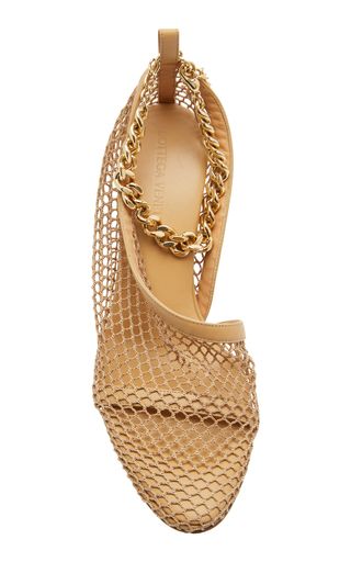a closeup view of beige mesh heeled sandals with a gold chain ankle strap. the shoes have a peeptoe design and a delicate mesh fabric that covers the entire shoe. they are perfect for summer and are sure to elevate any outfit.