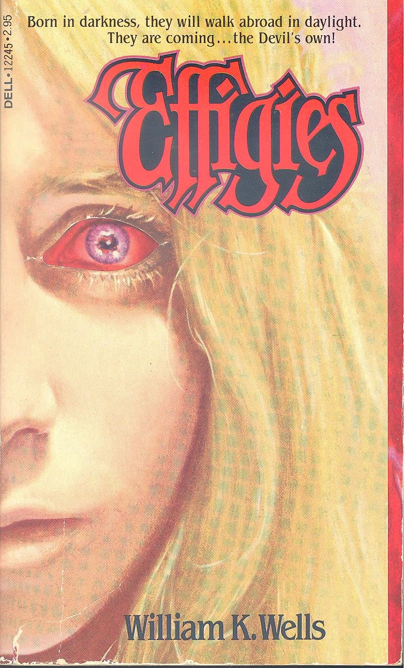 this is a scan of the cover of the paperback edition of william k. wells' horror novel "effigies."  the cover features a closeup of a young blonde woman's face, with one eye dramatically shown with bloodshot redness. the title "effigies" is prominently displayed in a stylized red font.  the book's tagline promises a supernatural horror story. the overall style is consistent with 1970s horror paperback covers.