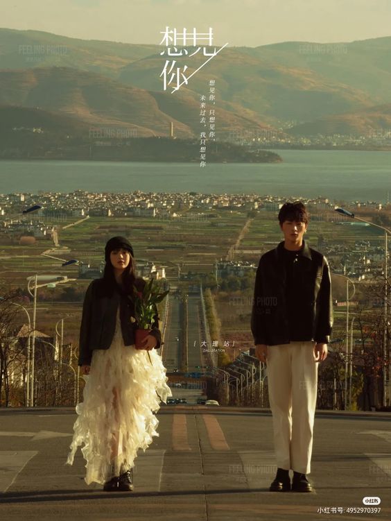 a movie poster featuring a young couple standing on a road overlooking a vast, rural landscape. the woman, wearing a white ruffled dress and black leather jacket, holds a potted plant. the man, in white pants and a black jacket, stands beside her. the scene is bathed in warm, sunset light, creating a romantic and nostalgic atmosphere. the chinese title of the movie is prominently displayed at the top, with additional text in smaller font providing details like actors and release date.