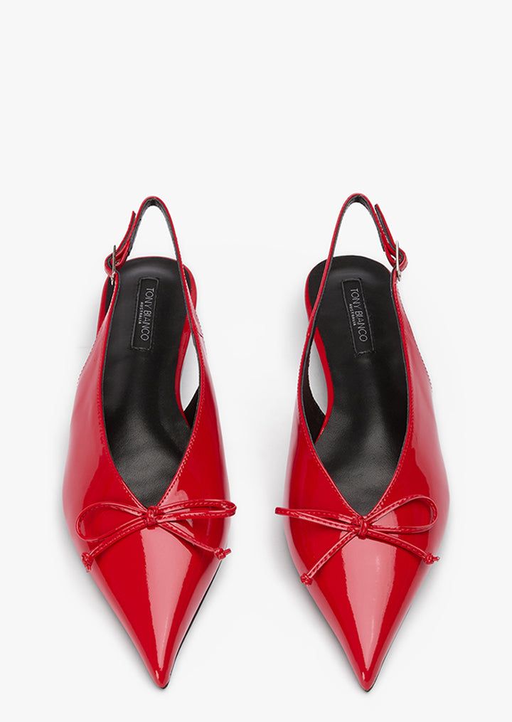 a pair of red patent leather slingback shoes with a bow on the toe. the shoes have a pointy toe and a high heel. they are elegant and formal, perfect for a party or a special occasion.