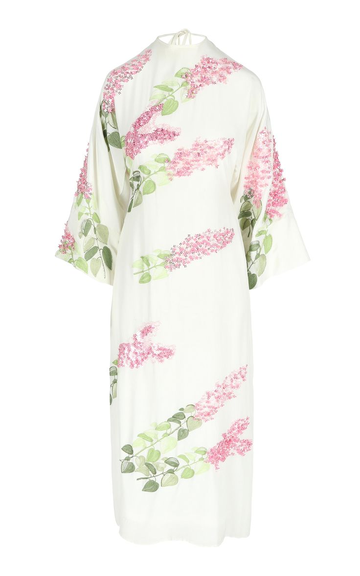 a white, longsleeved dress with a loose, comfortable fit and a floral print. the dress is covered in pink flowers and green leaves. it has a relaxed, casual style that is both elegant and chic. the dress would be perfect for a summer day or a casual evening out.