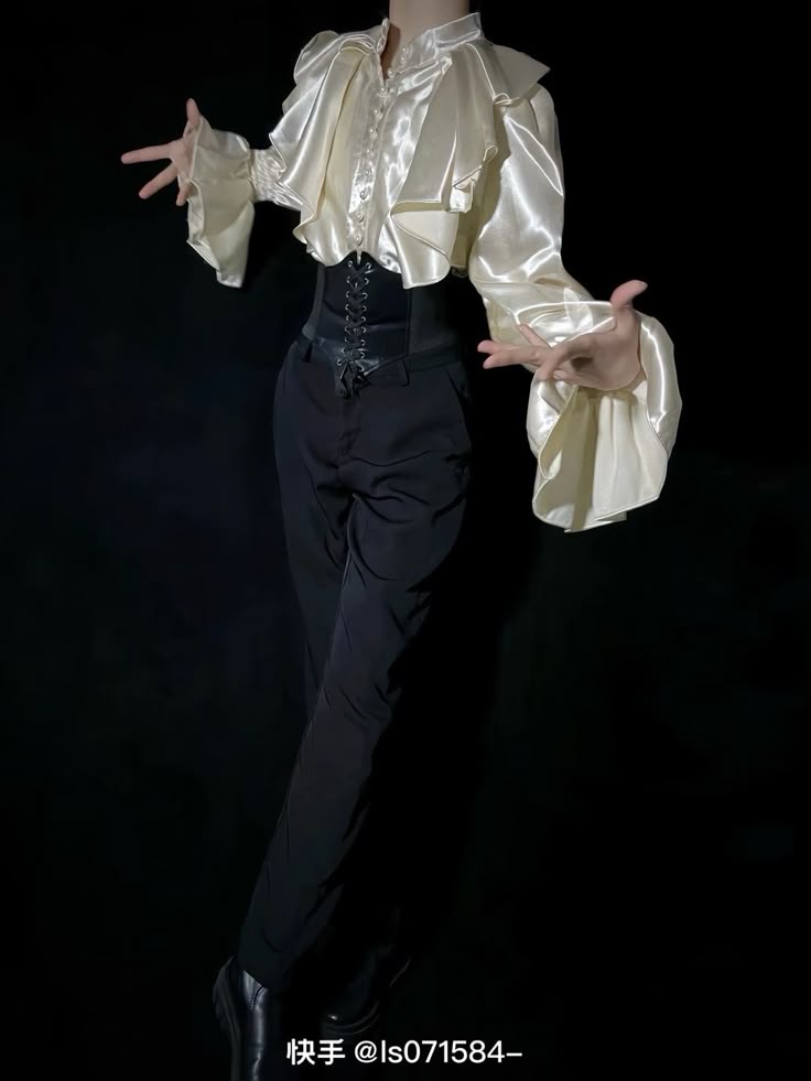 a person is standing against a black background, wearing a creamcolored satin ruffled shirt, a black corset over highwaisted black pants, and black dress shoes. they have their arms extended outwards with open hands.