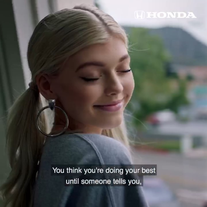 a young blonde woman with her hair in pigtails smiles slightly. she is wearing large hoop earrings. a honda logo is visible in the upper right corner, and text appears at the bottom of the frame, reading "you think you're doing your best until someone tells you."