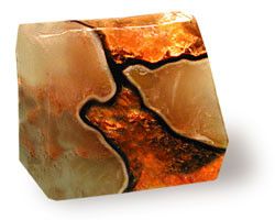 a closeup of a single bar of handmade natural soap. the soap is orange, brown and white and has a marbled appearance. the soap looks like a piece of natural agate stone.