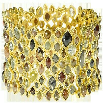 a closeup of a gold bracelet with diamonds. the bracelet is made of a delicate gold band with a row of diamonds on each side. the diamonds are of varying sizes and shapes, and they sparkle beautifully in the light. the bracelet is a luxurious and elegant piece of jewelry, perfect for a special occasion.
