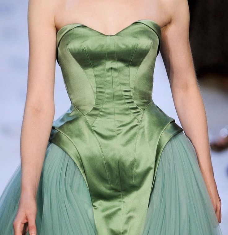 a closeup shot of a strapless green couture dress with a fitted bodice and tulle skirt.