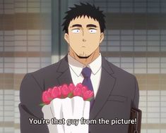 an anime still features a man in a suit, holding a bouquet of red roses. his expression is surprised and his eyes are wide. the background suggests an office or indoor setting. he's saying "you're that guy from the picture!".  the lighting is bright, suggesting daytime and an artificial light source. the perspective is at eye level, creating a feeling of direct engagement with the viewer.