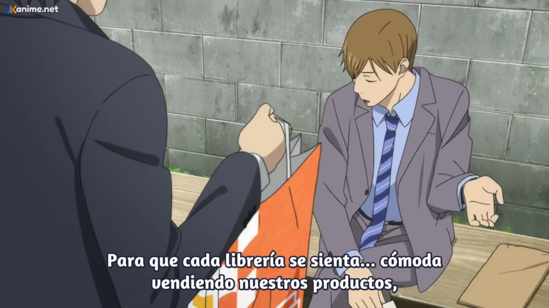 a screenshot from what appears to be an anime, featuring two men, one sitting on a bench and the other standing in front of him. the man standing is wearing a black suit, while the man sitting is wearing a gray suit. there is a brick wall in the background, with a glimpse of green suggesting trees above it.  the overall tone of the image suggests an overcast day. the bottom of the screenshot includes spanish subtitles.