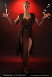 a fulllength studio shot of a woman cosplaying a scifi character, possibly a jedi or sith from star wars. she's wearing a brown dress and boots, holding two lightsabers. she is posing dramatically against a red backdrop. the image is dark and moody with dramatic lighting.