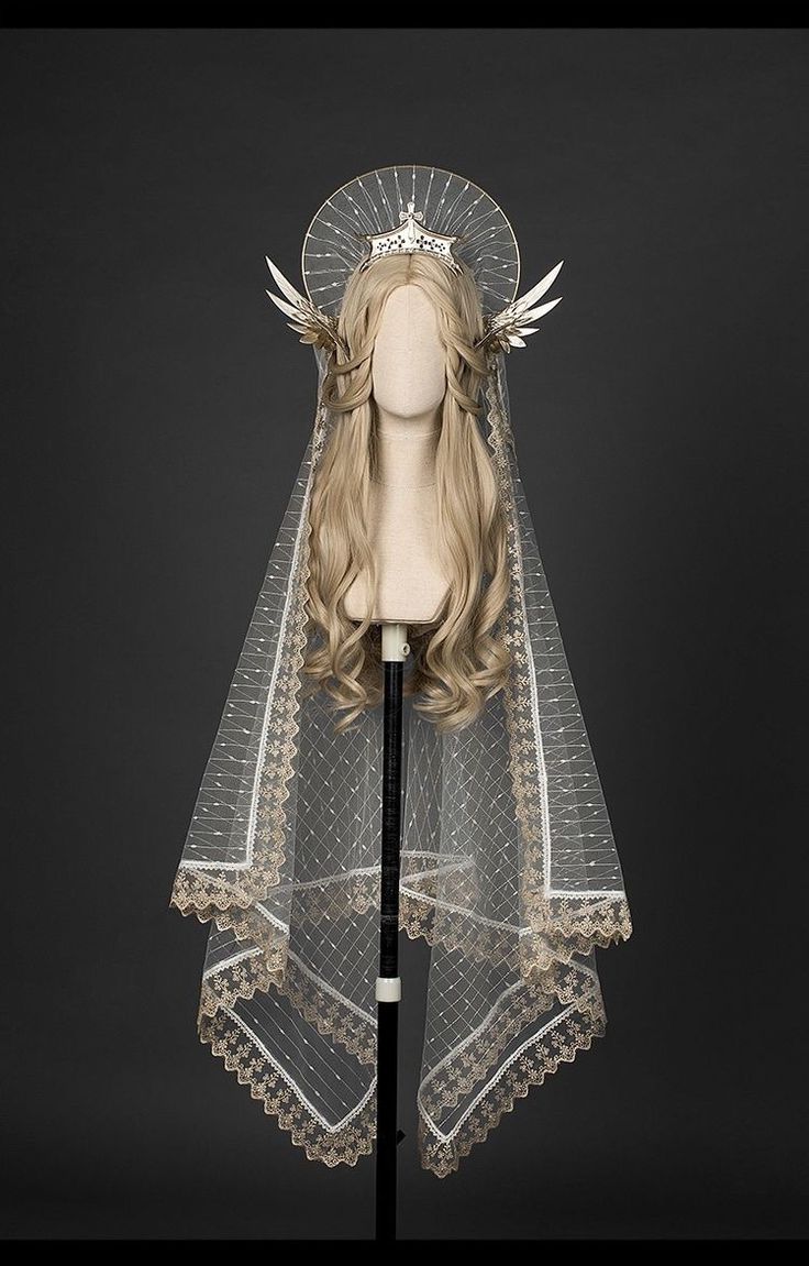 a delicate, sheer veil with intricate lace trim is draped over a mannequin head. the veil is paired with a celestialinspired crown featuring a halolike design and feather accents. the overall effect is ethereal and romantic, reminiscent of a goddess or queen from a fantasy realm.