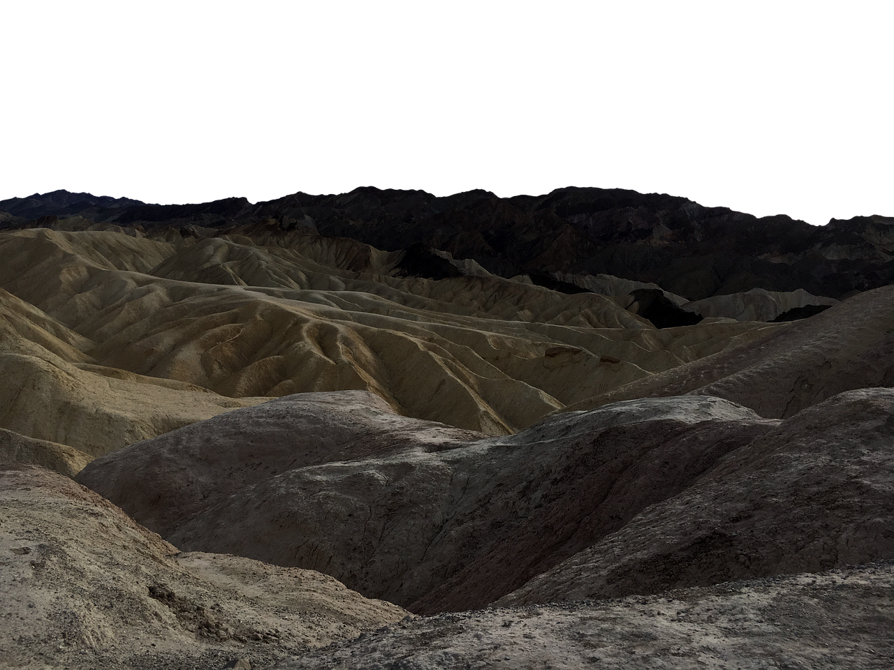 the image shows a stark desert landscape with rolling hills and distant mountains under a dark sky. the foreground is dominated by textured, rocky hills, while the midground reveals undulating, sandy ridges. in the background, darker mountain ranges add depth to the scene. the monochrome palette emphasizes the barren nature of the arid environment.