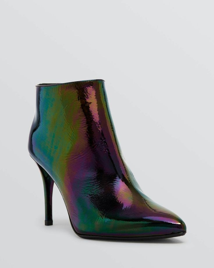 a single iridescent ankle boot with a pointed toe and stiletto heel is shown on a white background. the boot is predominantly black with shifting shades of green and purple due to its iridescent finish.  the image is a welllit product shot, focusing on the details and shine of the boot's material.