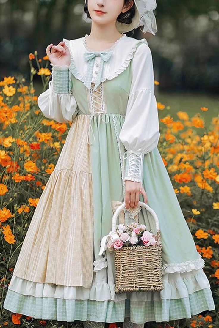 a woman in a vintageinspired dress stands in a field of yellow flowers. she is holding a wicker basket with pink roses in it. the dress is green, white, and beige, with lace and ruffle details. she is wearing a white hat and has a bow in her hair.