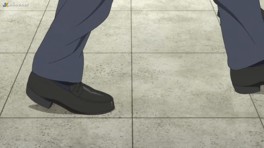 this is a screenshot of the lower half of a person wearing darkcolored dress pants and shoes walking to the right on a tiled floor. the lighting suggests they are indoors.