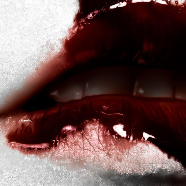 the image is a closeup, almost macro shot of a pair of lips wearing dark, glossy red lipstick. the lipstick appears to have a slightly cracked or textured finish, and the color is very intense and dark, almost approaching a bloodred hue.  the lighting and editing give the image a dramatic, almost gothic or grunge aesthetic. the background is blurred and out of focus, drawing attention entirely to the lips and their texture. the overall mood is sensual, mysterious, and slightly edgy.
