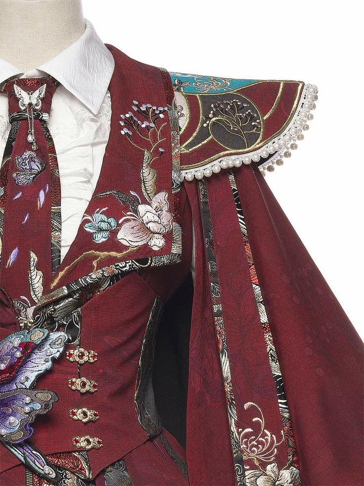loseup shot of a richly detailed alice and the pirates lolita dress. the dress is predominantly dark red, featuring intricate embroidery of flowers, butterflies, and other motifs.  a dark red cape with decorative trim, including pearls, is attached to the shoulders. the dress also incorporates a corsetstyle bodice and a highcollared white shirt underneath. the overall style blends gothic and vintage elements with a touch of fantasy. the level of detail in the embroidery and fabric is striking.
