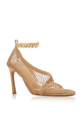 a pair of beige highheeled pumps with a net mesh upper and a gold chain ankle strap.  the shoes are stylish and elegant, perfect for a summer party or formal occasion.  they are also comfortable to wear thanks to the soft mesh fabric.