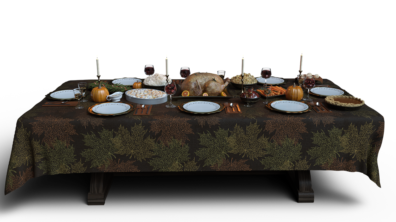 a thanksgiving dinner table setting is shown in the image. the table is covered with a brown tablecloth decorated with leaf patterns. in the center of the table, a roasted turkey is placed on a tray, surrounded by dishes of mashed potatoes, stuffing, cranberry sauce, and other side dishes. plates and silverware are set for each person, and wine glasses and candles add to the festive atmosphere. there are pumpkins and a pie on the table as well. the background is black.