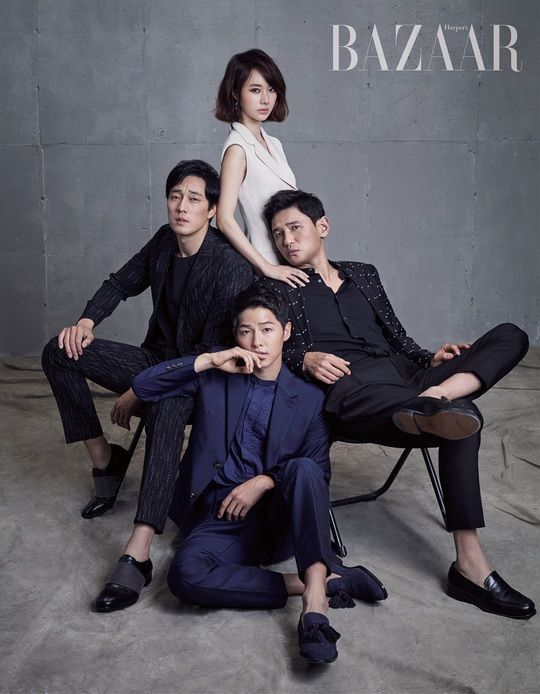 a group of korean actors pose for a photoshoot for harper's bazaar magazine.  the actors are all wearing suits and sitting on a gray background.  the woman in the center is wearing a white dress. the actors all look serious and are welldressed for the photoshoot.