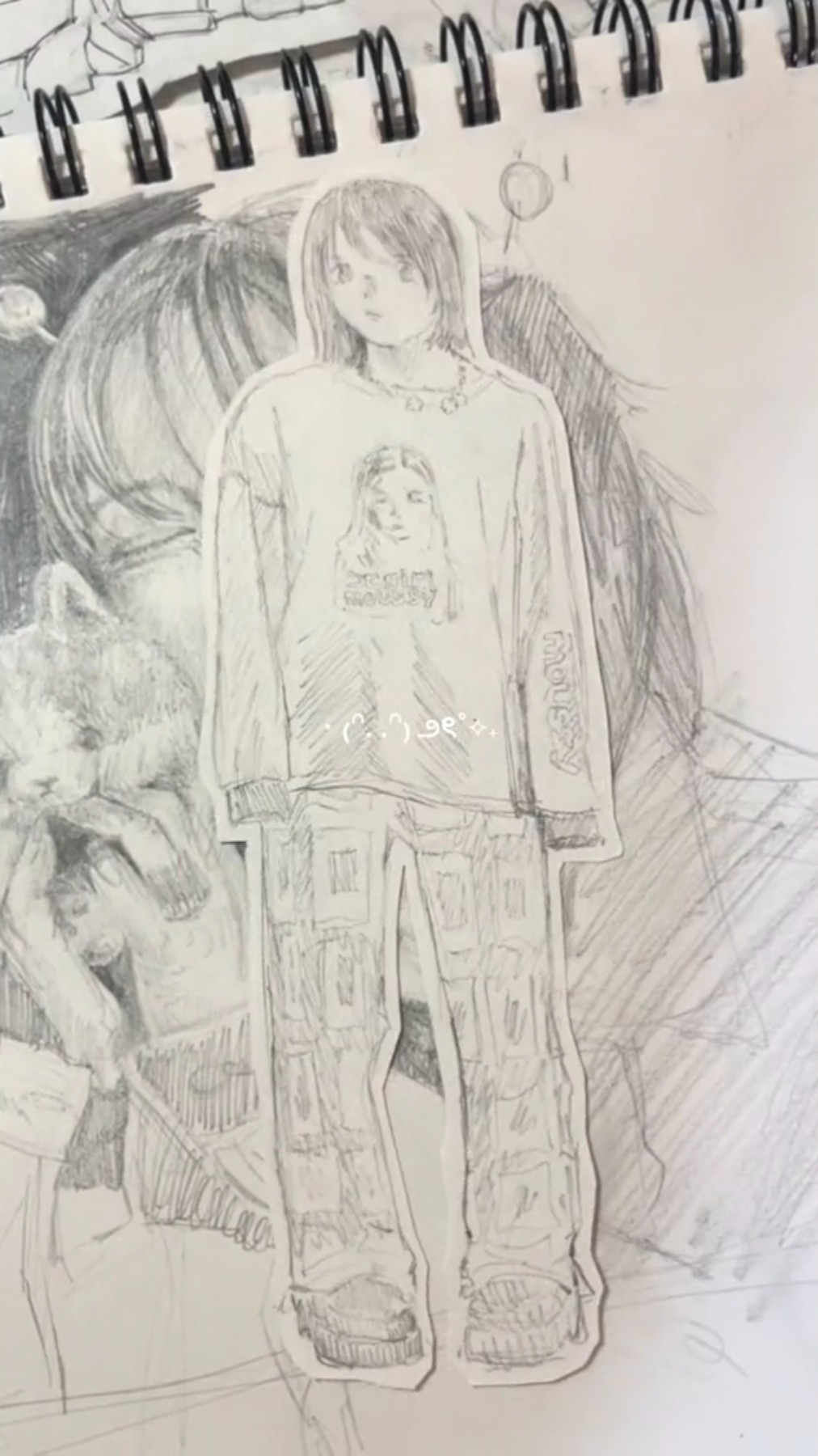 a black and white sketch of a female fashion figure drawn on paper. she is wearing a longsleeved tshirt with another woman's face printed on it, paired with patterned pants and chunky shoes.  the figure seems to be cut out and layered on top of another, less detailed sketch of a similar style. the background is a simple, white sketchbook page with faint grid lines. the drawing style is loose and expressive.