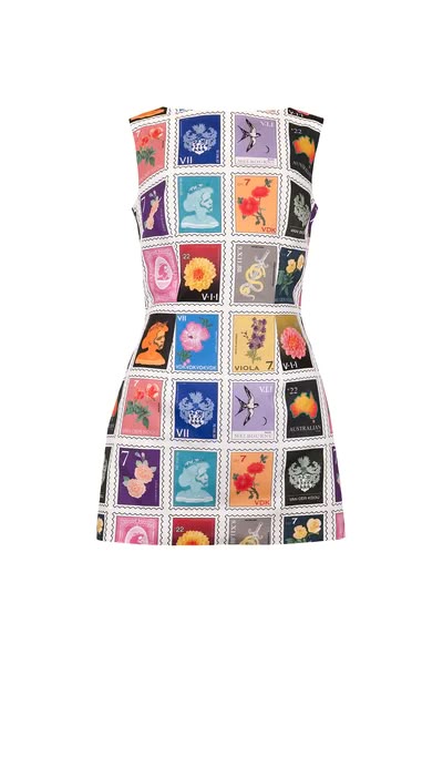 a sleeveless, mini dress featuring a vibrant collage of postage stamp prints. the stamps depict a variety of images, including flowers, portraits, and other designs, creating a colorful and unique pattern throughout the dress.